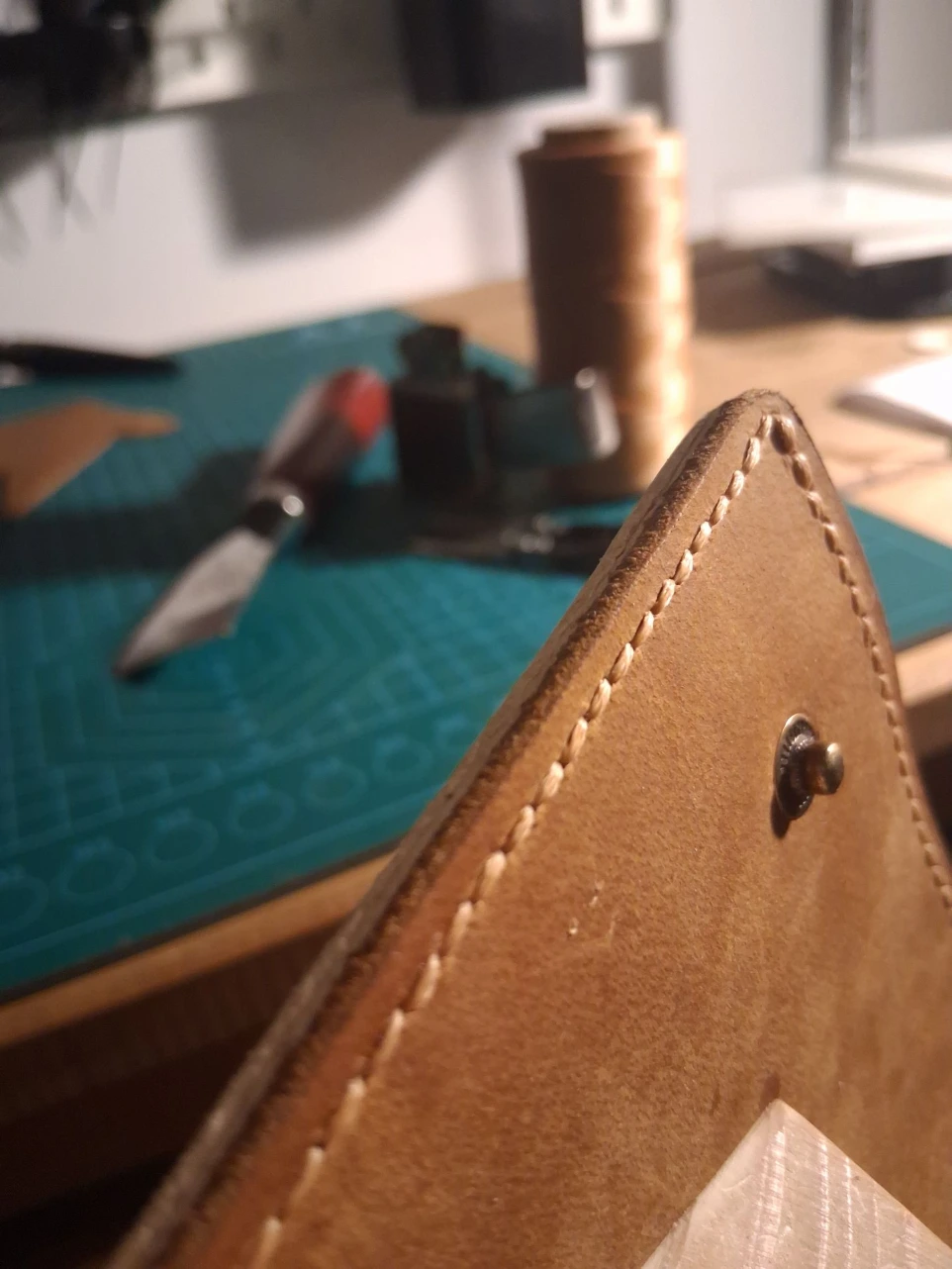 Image of leather wallet being held in stitching horse for hand stitching