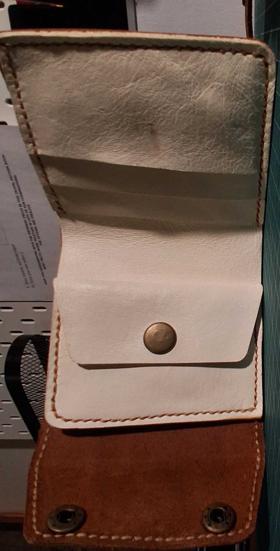 Image of handmade trifold leather wallet laid open for visibility